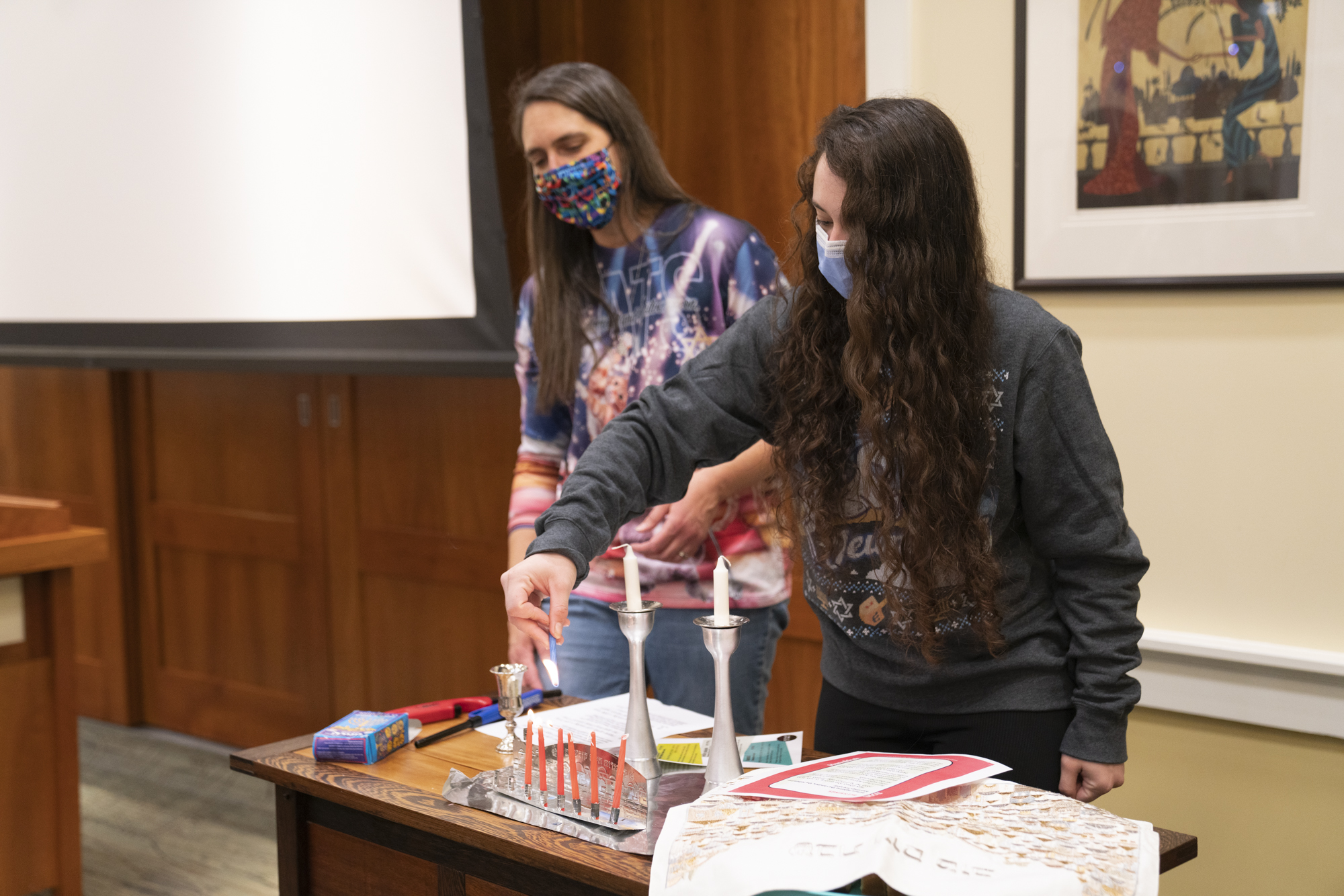 Religious Life Chair Ellie Sherman '23 leads the candle lighting on the sxith night of Hanukkah at Hanukkah Shabbat.